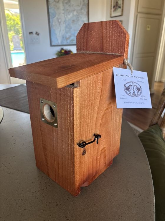 A tung-oiled redwood birdhouse with a Bennett Valley Woodworks hang tag.